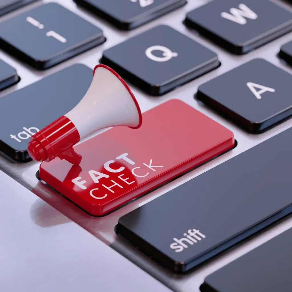 A red key labeled "FACT CHECK" with a megaphone on a keyboard, representing online fact-checking services.