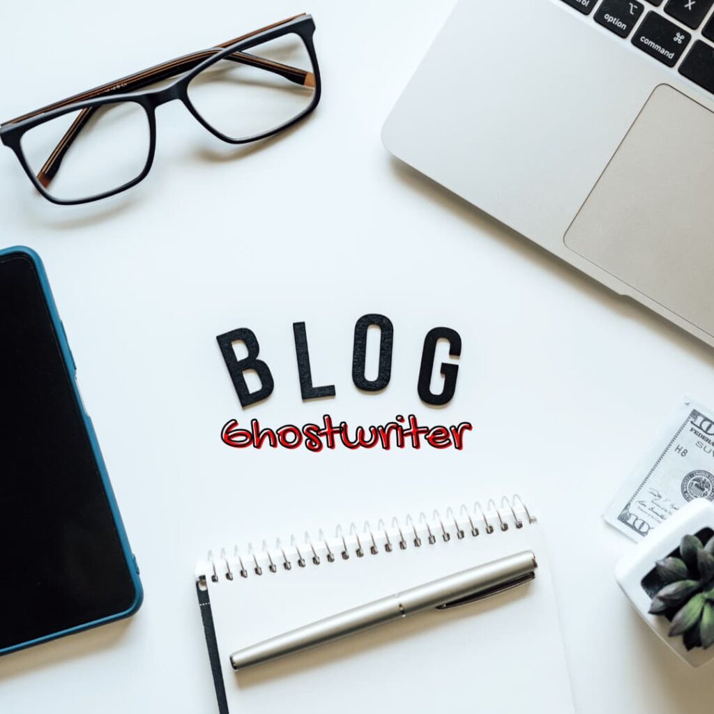 A workspace with a laptop, smartphone, glasses, and a notebook. The word 'BLOG' is prominently displayed along with the term 'ghostwriter,' representing blog ghostwriting services.