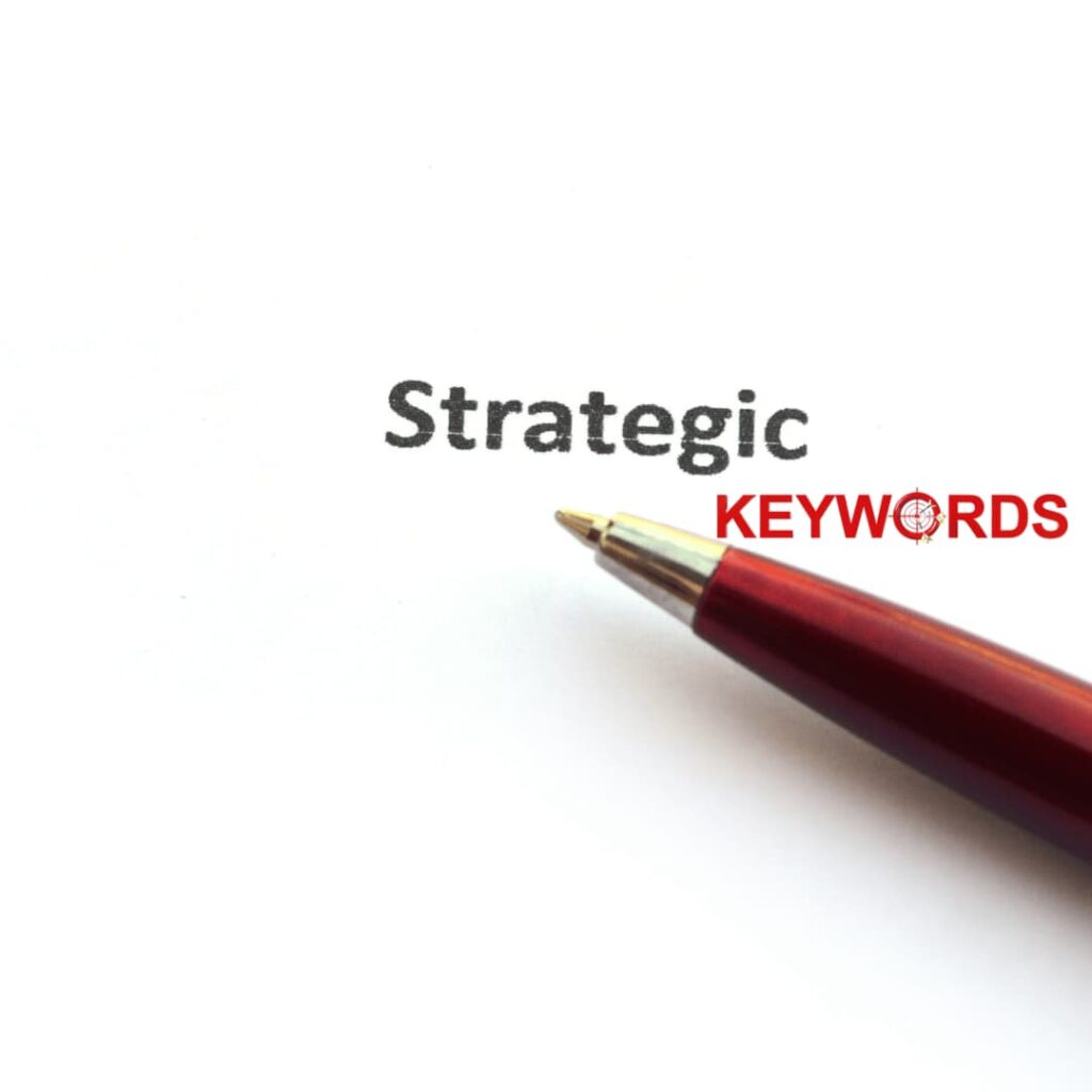 A close-up of a red pen writing the words 'Strategic Keywords' on a white paper, highlighting the importance of keyword research in SEO Blog writing services.